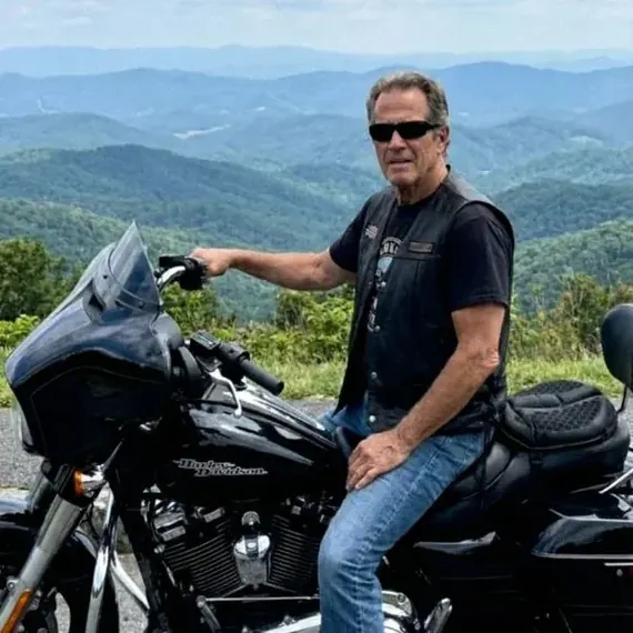 Giorgio L. sulla sua Harley-Davidson, con vista sulle montagne